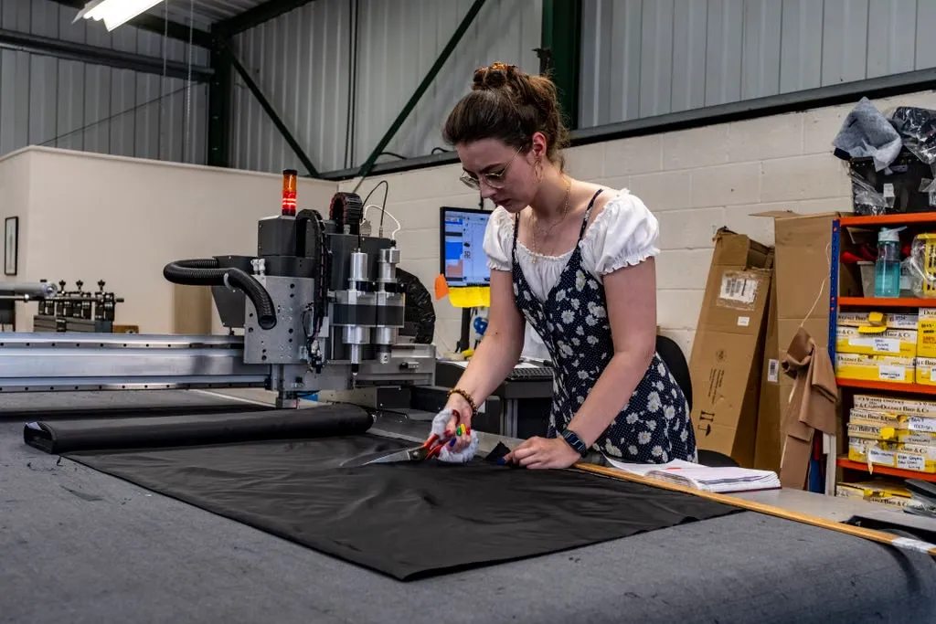 uk factory worker cutting cloth